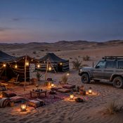 Dubai desert safari camp at dusk with 4x4 vehicle and glowing lanterns